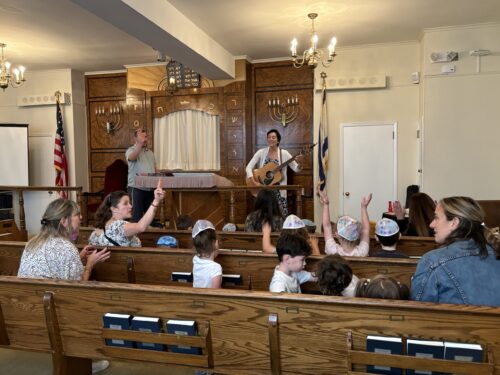 Shalom Yeladim children with some teachers, singing in the chapel with Cantor Shana and Rabbi Gillman.